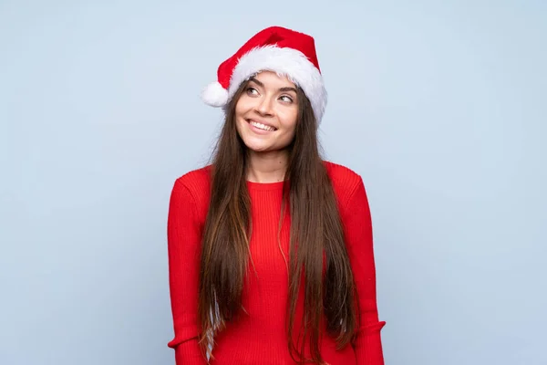 戴着圣诞礼帽的女孩 带着淡淡的蓝底笑着抬头看 — 图库照片