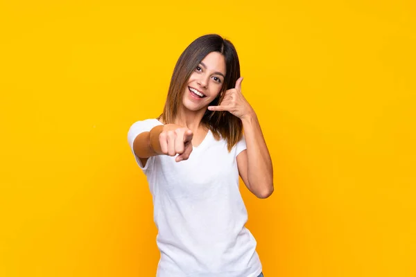 Jovem Mulher Sobre Fundo Amarelo Isolado Fazendo Gesto Telefone Apontando — Fotografia de Stock