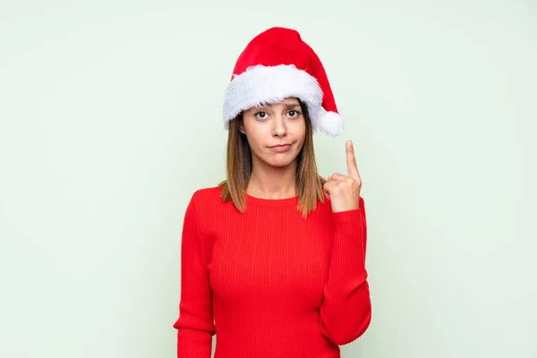 Девушка Рождественской Шляпе Изолированном Зеленом Фоне Указывая Указательным Пальцем Отличная — стоковое фото