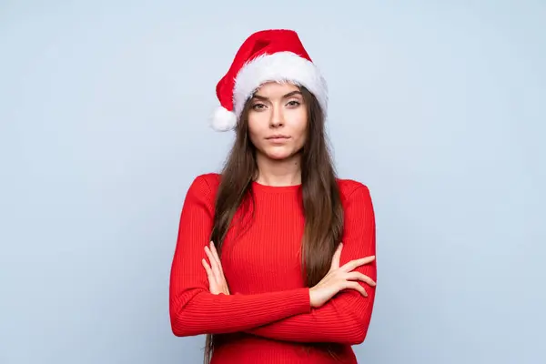 Meisje Met Kerst Hoed Geïsoleerde Blauwe Achtergrond Houden Armen Gekruist — Stockfoto