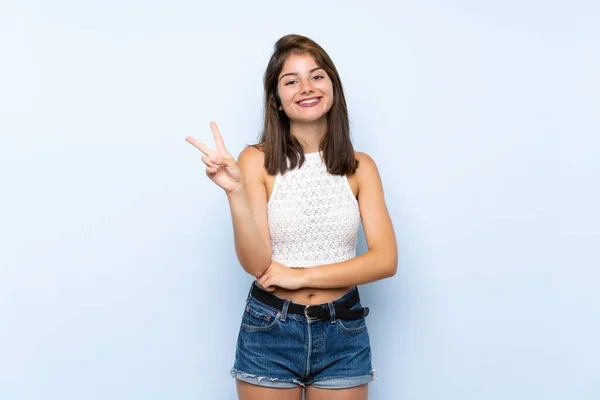 Zole Edilmiş Mavi Arka Planda Genç Bir Kadın Gülümsüyor Zafer — Stok fotoğraf