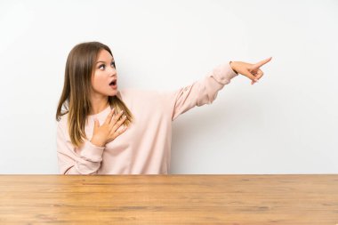 Yan parmak gösteren bir masada Genç kız