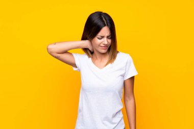 Boyun ağrısı ile izole sarı arka plan üzerinde genç kadın