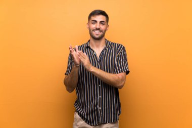 Arkaplanda sakallı yakışıklı bir adam bir konferanstan sonra alkışlıyor.