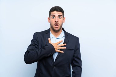 Yakışıklı adam mavi arka planda, sağa bakarken şaşırmış ve şok olmuştu.