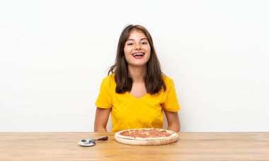 Suratı şaşkın bir şekilde pizza yiyen beyaz kız.
