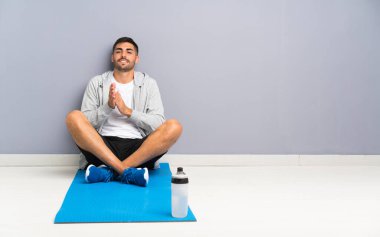 Spor adamı yerde oturmuş alkışlıyor.