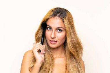 Makyaj fırçası ile genç sarışın kadın