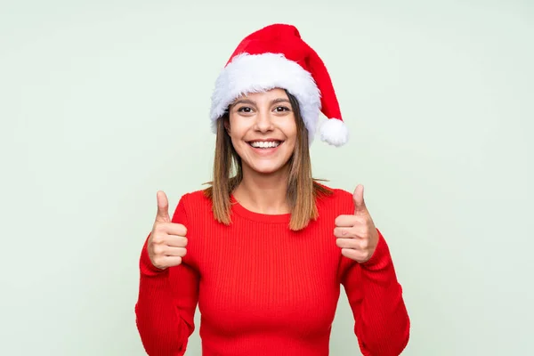 Girl Christmas Hat Isolated Green Background Giving Thumbs Gesture — ストック写真