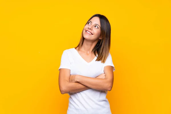 Mujer Joven Sobre Fondo Amarillo Aislado Mirando Hacia Arriba Mientras — Foto de Stock