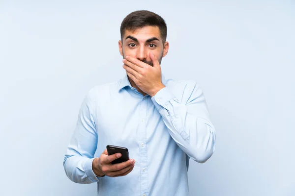 Joven Hombre Guapo Con Móvil Sobre Una Pared Azul Aislada — Foto de Stock