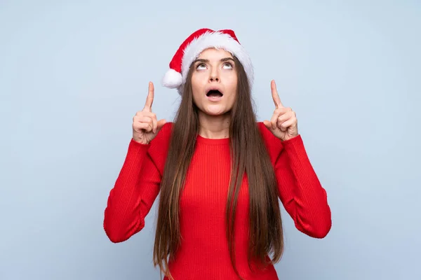 Zole Edilmiş Mavi Arka Planda Noel Şapkalı Kız Işaret Parmağıyla — Stok fotoğraf