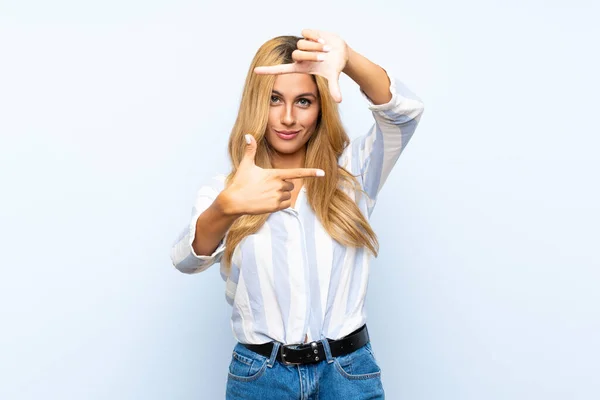 Молодая Блондинка Изолированном Синем Фоне Фокусирующая Лицо Символ Обрамления — стоковое фото