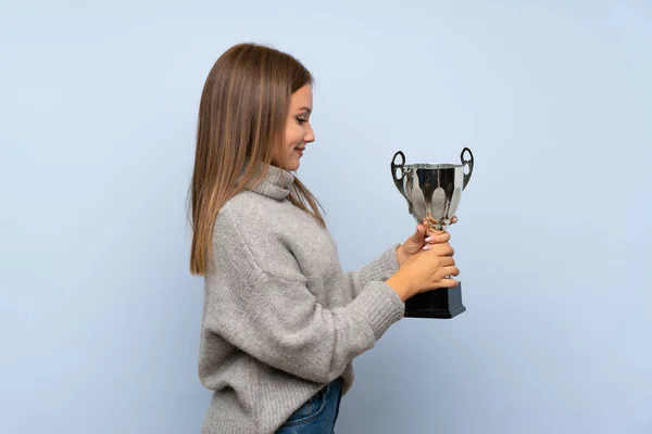 Ragazza Adolescente Con Maglione Sfondo Blu Isolato Possesso Trofeo — Foto Stock