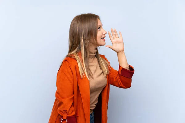 Menina Adolescente Com Casaco Sobre Fundo Azul Isolado Gritando Com — Fotografia de Stock