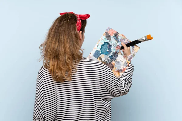 Young Artist Woman Holding Palette Isolated Blue Background Back Position — Stock Photo, Image