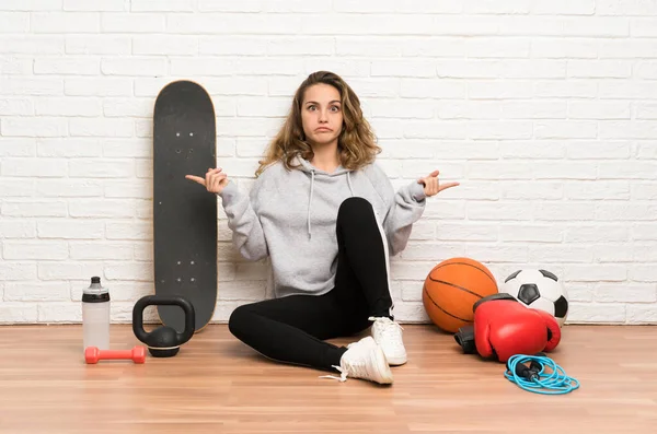 Jeune Femme Sportive Assise Sur Sol Pointant Vers Les Côtés — Photo