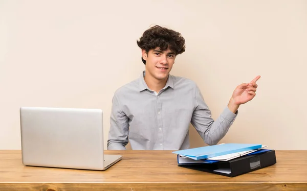 Dizüstü Bilgisayarlı Genç Bir Öğrenci Yan Tarafı Işaret Ediyor — Stok fotoğraf