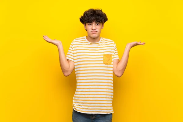 Young Man Isolated Yellow Wall Having Doubts While Raising Hands — Stock Photo, Image