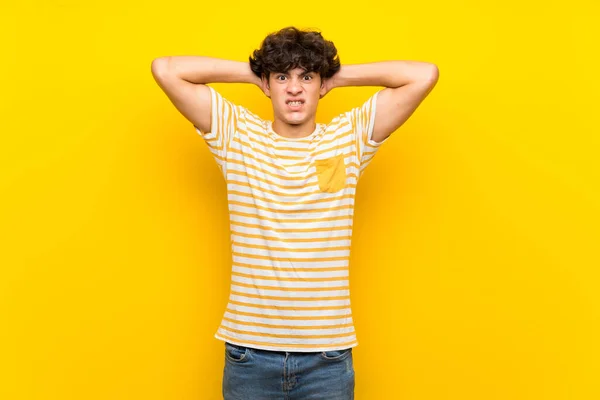 Junger Mann Über Isolierte Gelbe Wand Frustriert Und Nimmt Hände — Stockfoto