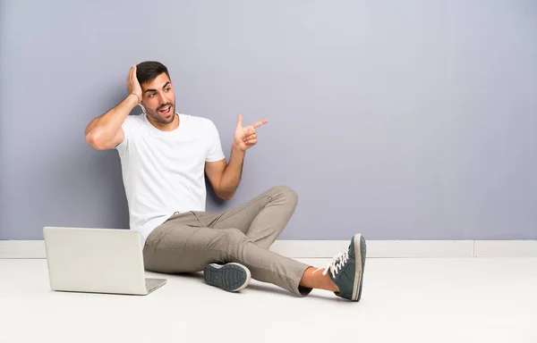 Jovem Com Seu Laptop Sentado Chão Surpreso Apontando Dedo Para — Fotografia de Stock