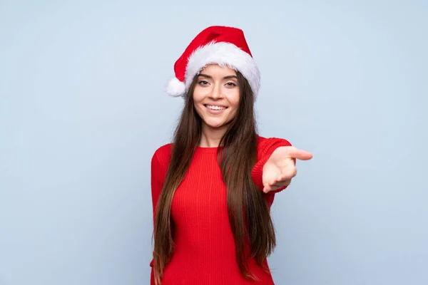 Meisje Met Kerst Hoed Geïsoleerde Blauwe Achtergrond Handschudden Goed Deal — Stockfoto