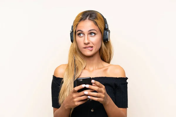Young Blonde Woman Listening Music Mobile Thinking Isolated Background — Stock Photo, Image