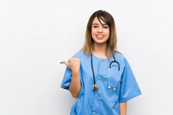 Jonge Verpleegster Vrouw Witte Muur Wijzend Naar Zijkant Een Product — Stockfoto