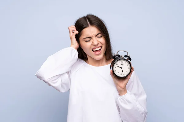 Jonge Vrouw Geïsoleerde Blauwe Achtergrond Met Vintage Wekker — Stockfoto