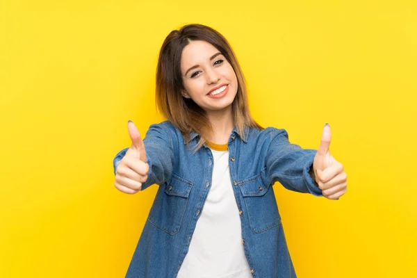 Jovem Mulher Sobre Fundo Amarelo Dando Gesto Polegares Para Cima — Fotografia de Stock