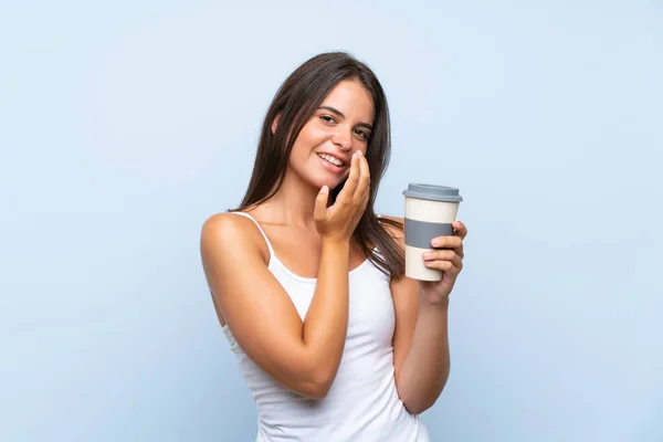 Młoda Kobieta Trzymająca Kawę Wydzielonym Niebieskim Tle Uśmiechająca Się — Zdjęcie stockowe