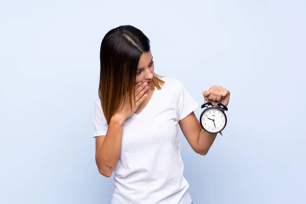 Jonge Vrouw Geïsoleerde Blauwe Achtergrond Met Vintage Wekker — Stockfoto