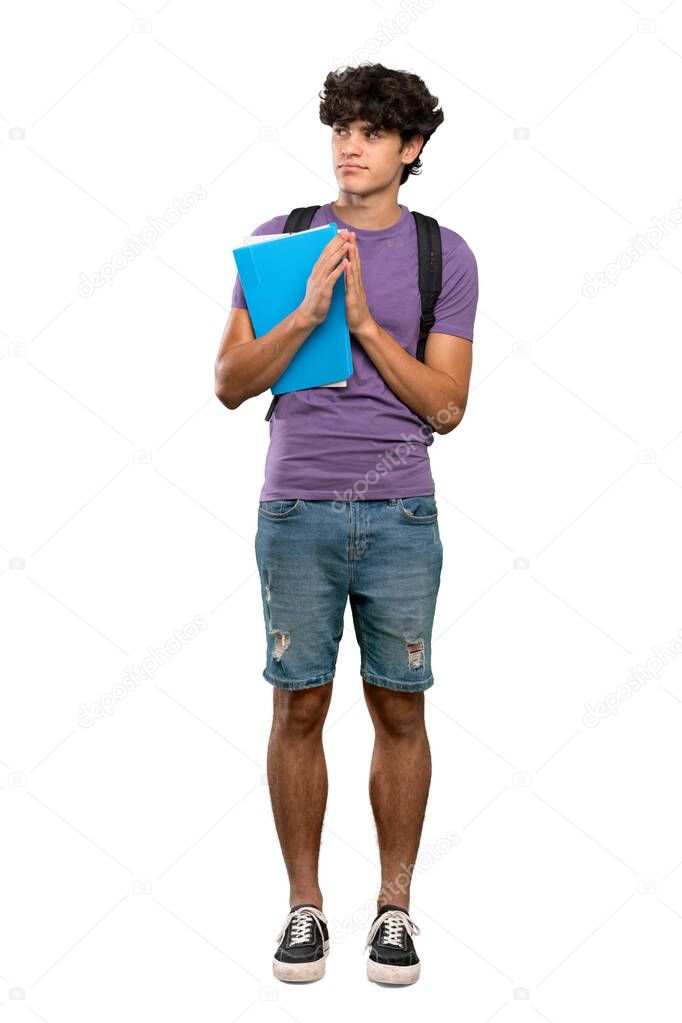 A full-length shot of a Young student man scheming something over isolated white background