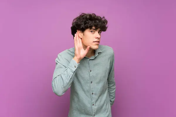 Joven Sobre Aislada Pared Púrpura Escuchando Algo Poniendo Mano Oreja — Foto de Stock