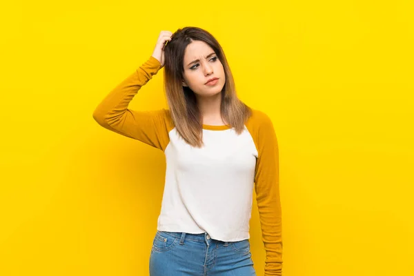 Mujer Joven Bonita Sobre Pared Amarilla Aislada Que Tiene Dudas — Foto de Stock