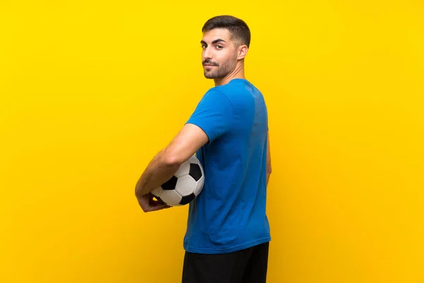 Молодий красивий футболіст над ізольованою жовтою стіною — стокове фото