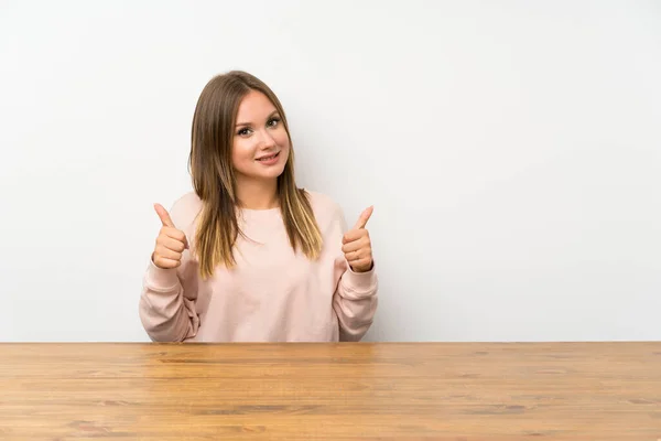 Ragazza Adolescente Tavolo Dando Pollice Gesto — Foto Stock