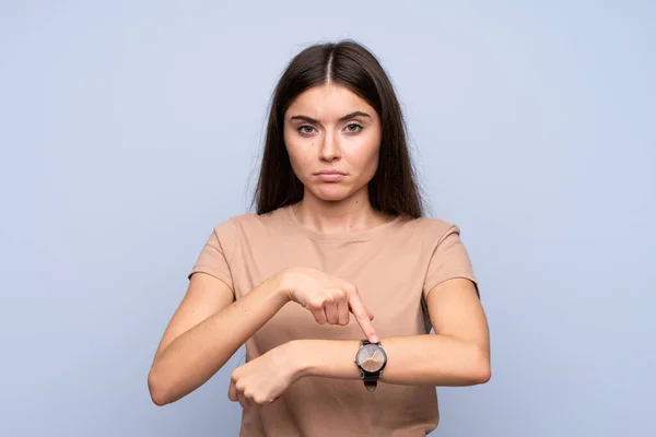 Ung Kvinna Över Isolerad Blå Bakgrund Som Visar Handen Klocka — Stockfoto