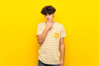 İzole edilmiş sarı duvarlı genç adam.