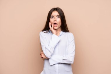 Izole arka plan üzerinde genç kadın şaşırttı ve doğru bakarken şok