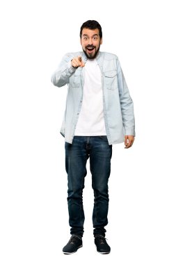 Sakallı, yakışıklı bir adamın, izole edilmiş beyaz arka plan üzerinde şaşırmış ve ön tarafı işaret ettiği uzun bir fotoğraf.