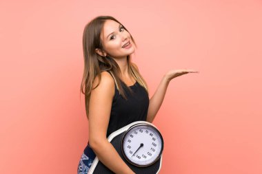 Izole arka plan üzerinde tartım makinesi ile Genç kız