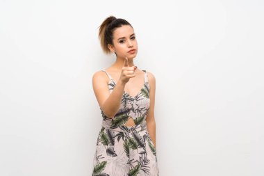 İzole edilmiş beyaz arka planı olan genç bir kadın hayal kırıklığına uğramış ve ön tarafı işaret ediyor.