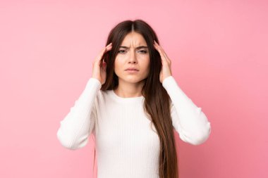 Izole pembe arka plan üzerinde genç kadın mutsuz ve bir şey ile sinirli. Negatif yüz ifadesi