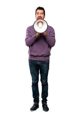 Yakışıklı bir megafon ile izole beyaz arka plan üzerinde bağırarak kazak ile tam uzunlukta atış