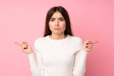 Soyutlanmış pembe arka planda genç bir kadın. Yan taraftakilerin şüpheleri olduğunu gösteriyor.