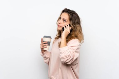 Genç sarışın kadın uzak ve bir cep almak için kahve tutan