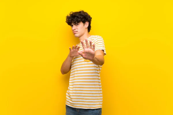 Jovem Sobre Parede Amarela Isolada Nervoso Esticando Mãos Para Frente — Fotografia de Stock
