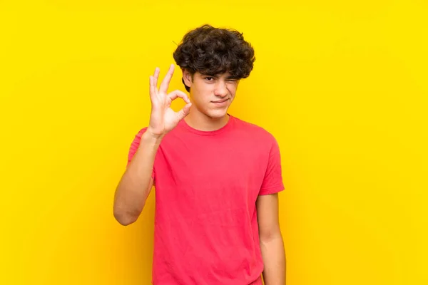 Joven Sobre Aislada Pared Amarilla Mostrando Signo Con Los Dedos — Foto de Stock
