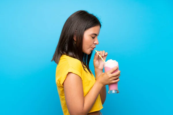 Chica Joven Con Batido Fresa Sobre Fondo Azul Aislado —  Fotos de Stock